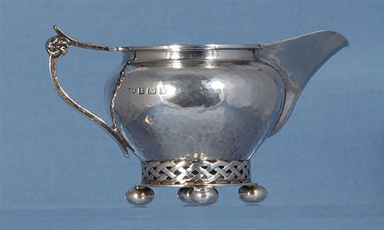 A George V planished silver Arts & Crafts sugar bowl and cream jug, by Albert Edward Jones, jug height 82mm, weight 10.3oz/321grms.